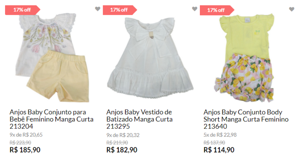 Na imagem há três roupas para bebê menina. A da esquerda é um conjunto de blusa branca e short amarelo. A do meioé um vestidobranco. À esquerda um conjunto com blusa amarela e short branco,amarelo, rosa e verde.