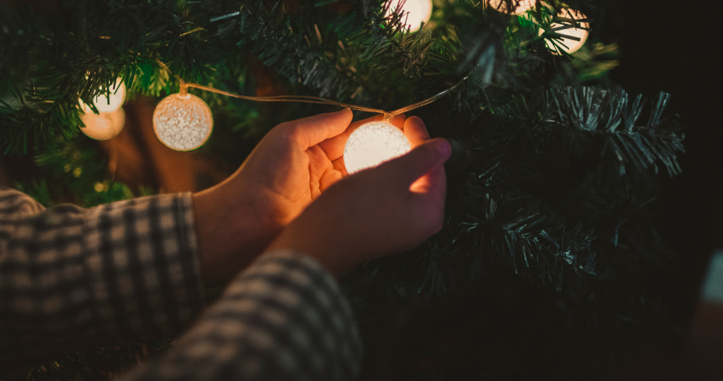 A imagem de boas festas disponibilizada no blog da Se-An Junior mostra um par de mãos segurando uma luzinha de Natal da árvore natalina.